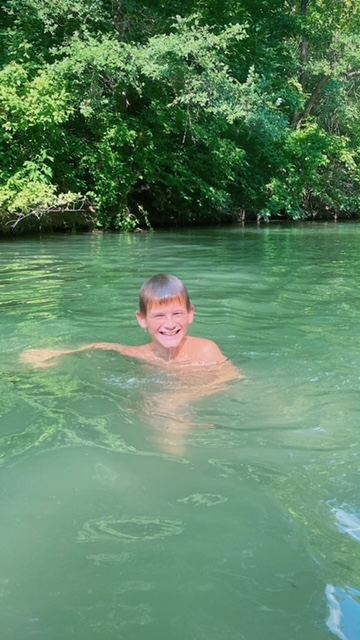 Boy swimming in the creek